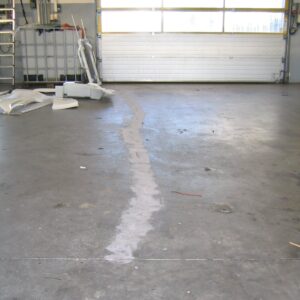 Revne i gulvet ud mod en portåbning efter epoxyfugning og efterfølgende slibning af gulvet.